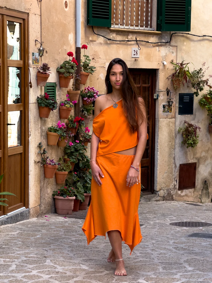 A model wearing an orange Sanni design in Mallorca